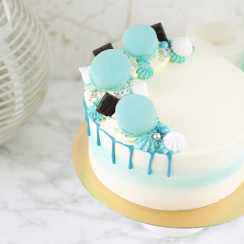 blue party taart met drip, macarons en chocolade decoratie