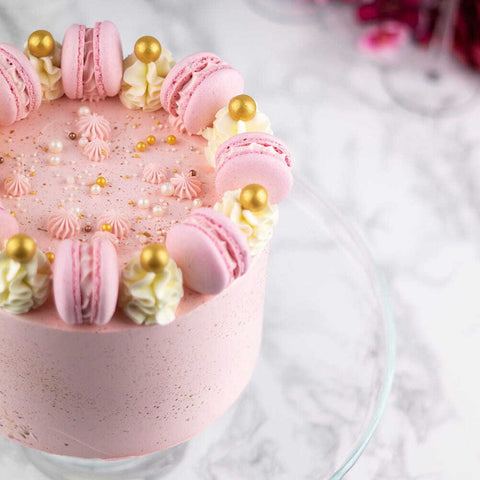 Roze taart met macarons en gouden accenten